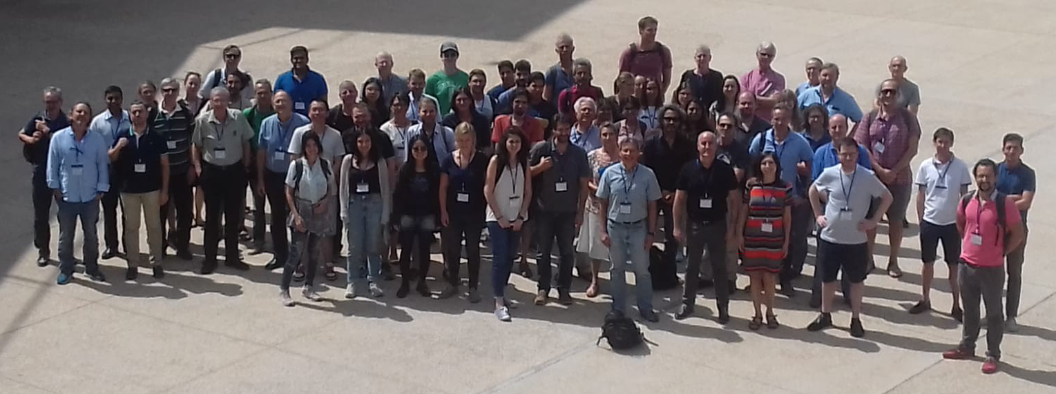 Participants of the conference (a group of about a hundred people) looking up at the camera.