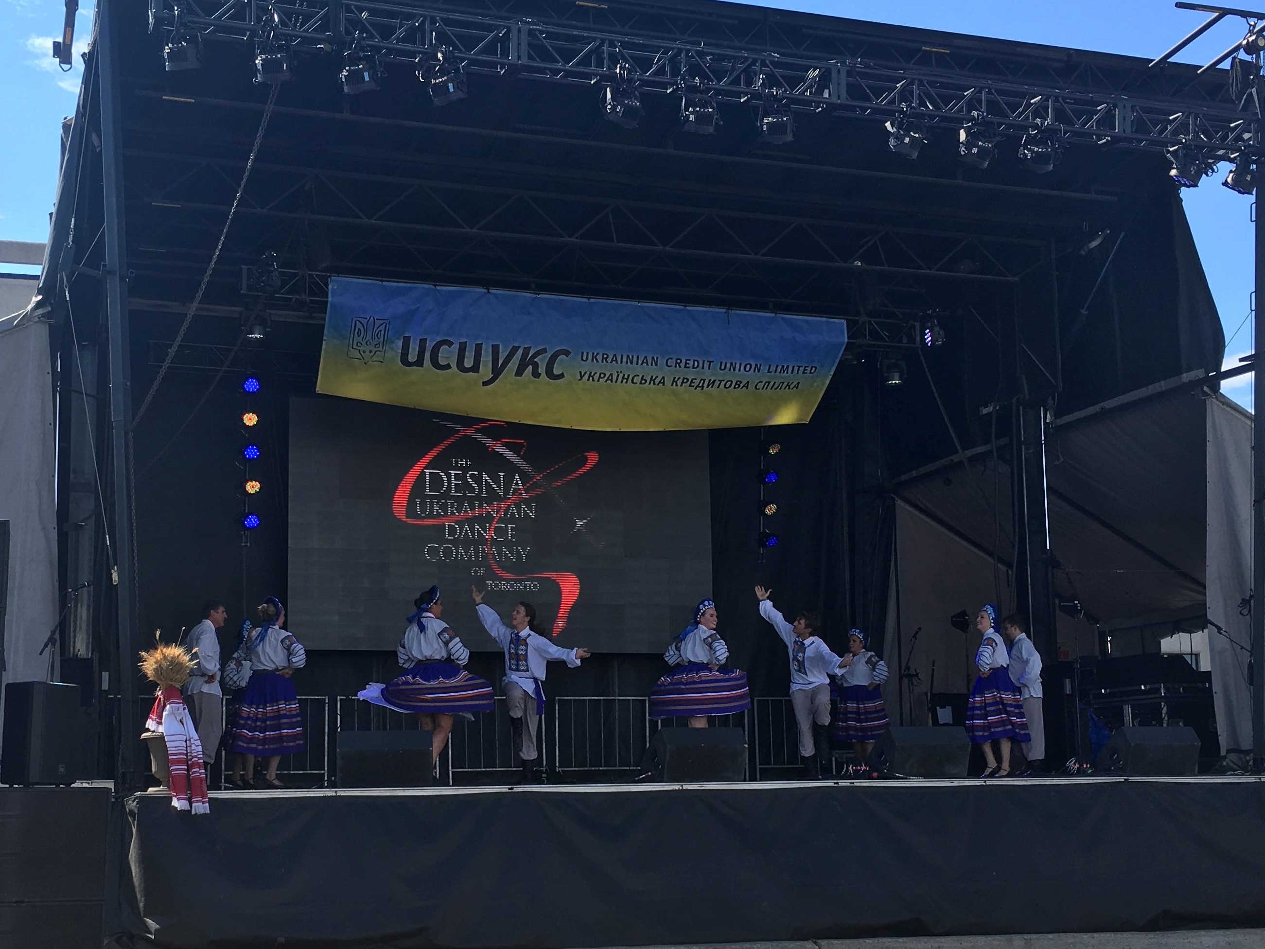 Four couples performing at the stage. Desna name and logo can be seen in the back.